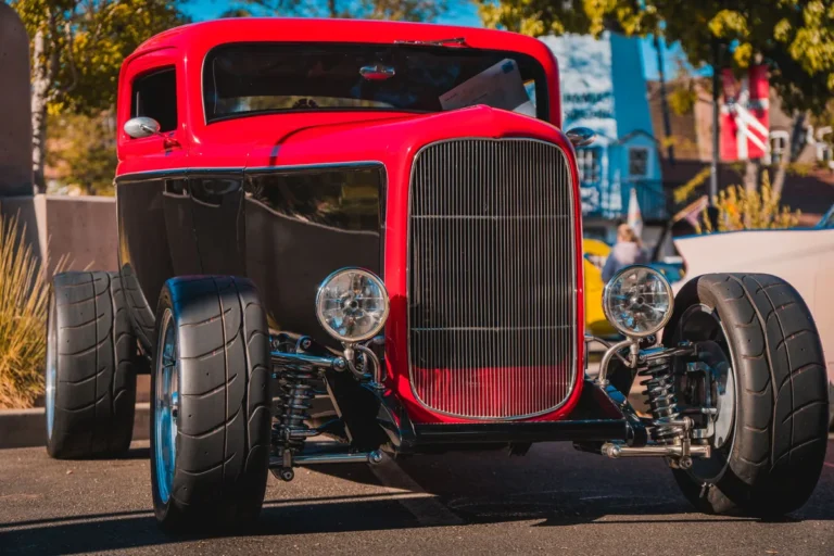 Red and black hot rod on display at an outdoor car show