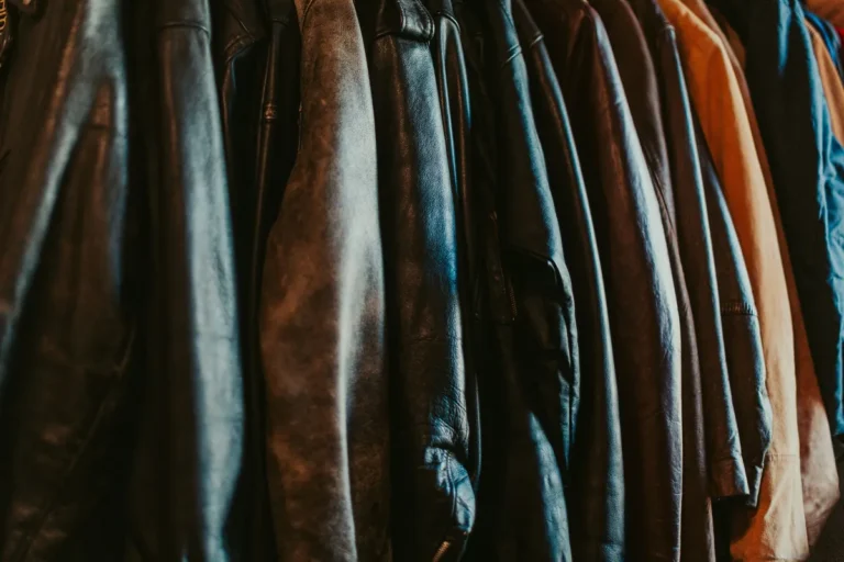 Row of worn leather jackets hanging on a shop rack