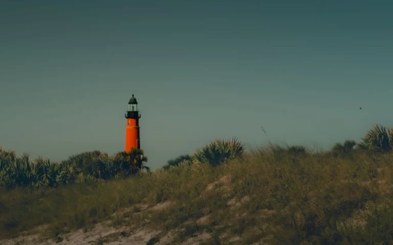 Ponce de Leon Inlet Lighthouse rising above palmetto-covered dunes at dusk, south of Daytona Beach, FL