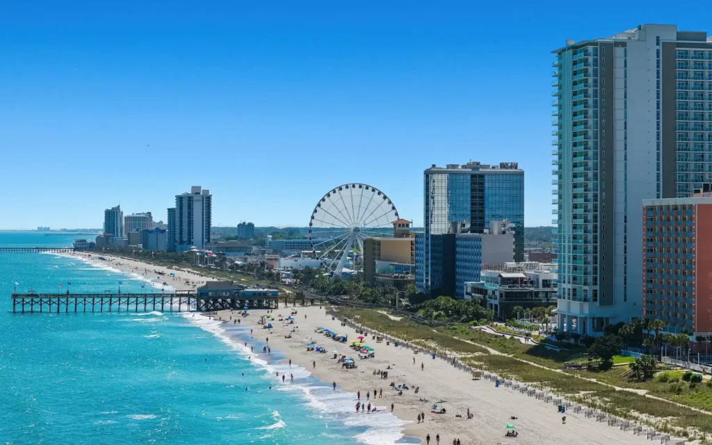 Aerial view of Myrtle Beach, SC: oceanfront towers, the SkyWheel, a fishing pier and turquoise surf