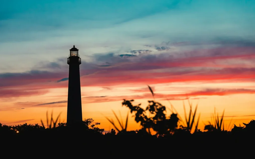 Cape May Lighthouse silhouetted against a red and orange sunset sky, Cape May, New Jersey