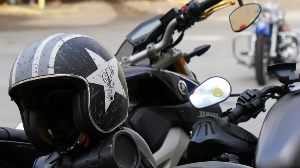 Open-face helmet resting on a motorcycle's handlebars, more bikes parked behind