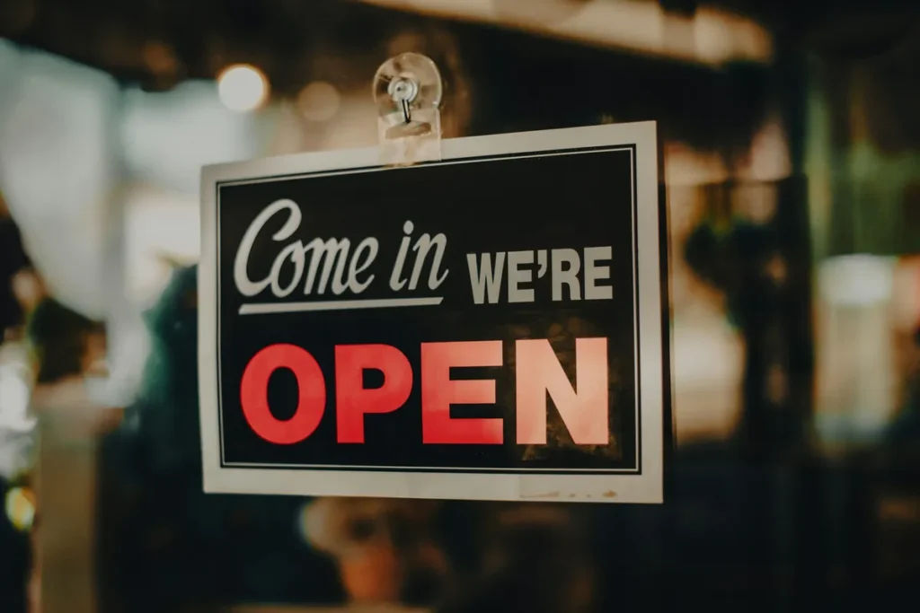 Come in, we're open sign hanging in a shop door window